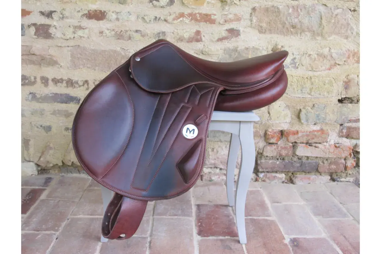 Magnifique selle d'équitation en cuir brun, ornée du logo "M". Parfaite pour les cavaliers exigeants.