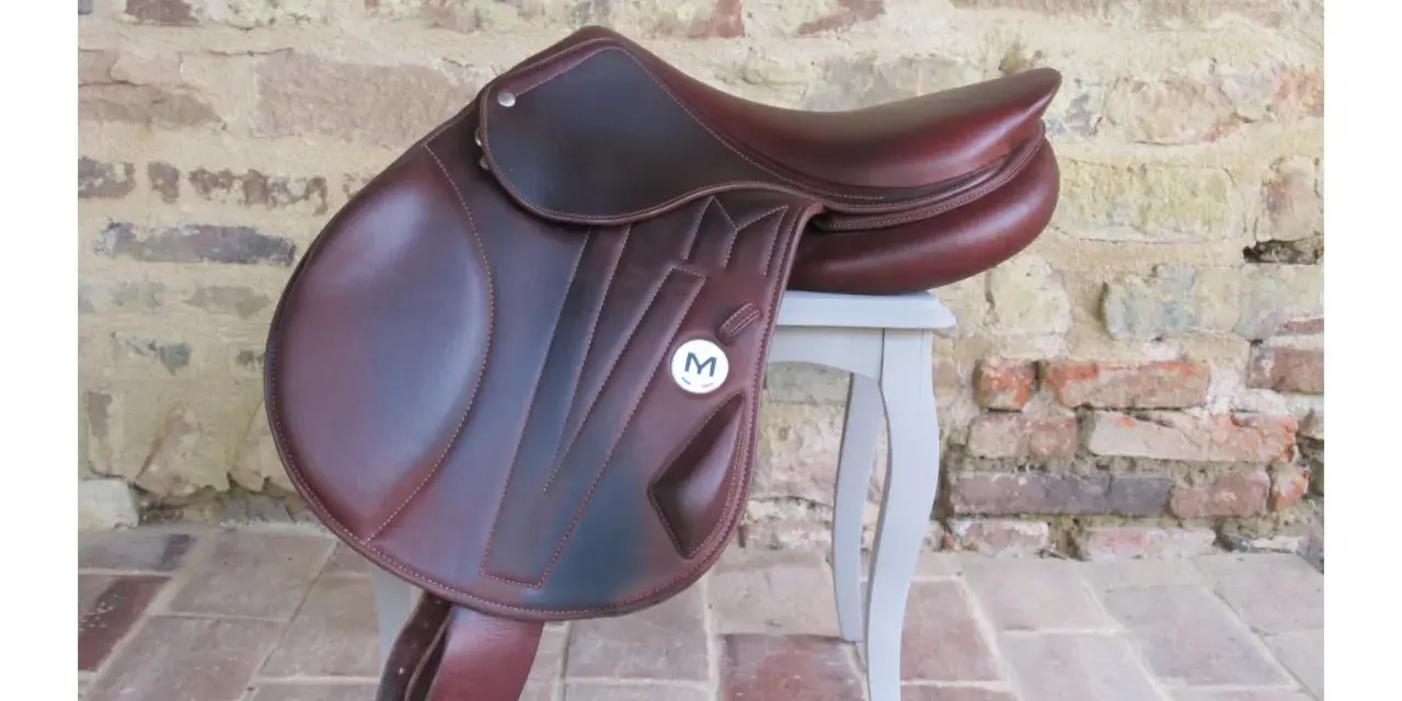 Magnifique selle d'équitation en cuir brun, ornée du logo "M". Parfaite pour les cavaliers exigeants.