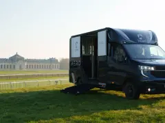 Le camion Theault Aero, prêt pour le transport équin, se dresse sur l'herbe devant un château majestueux.