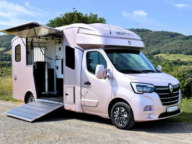 Un élégant Renault Master chevaux rose nacré, prêt pour le transport. La rampe est abaissée, invitant vos précieux compagnons à monter à bord.