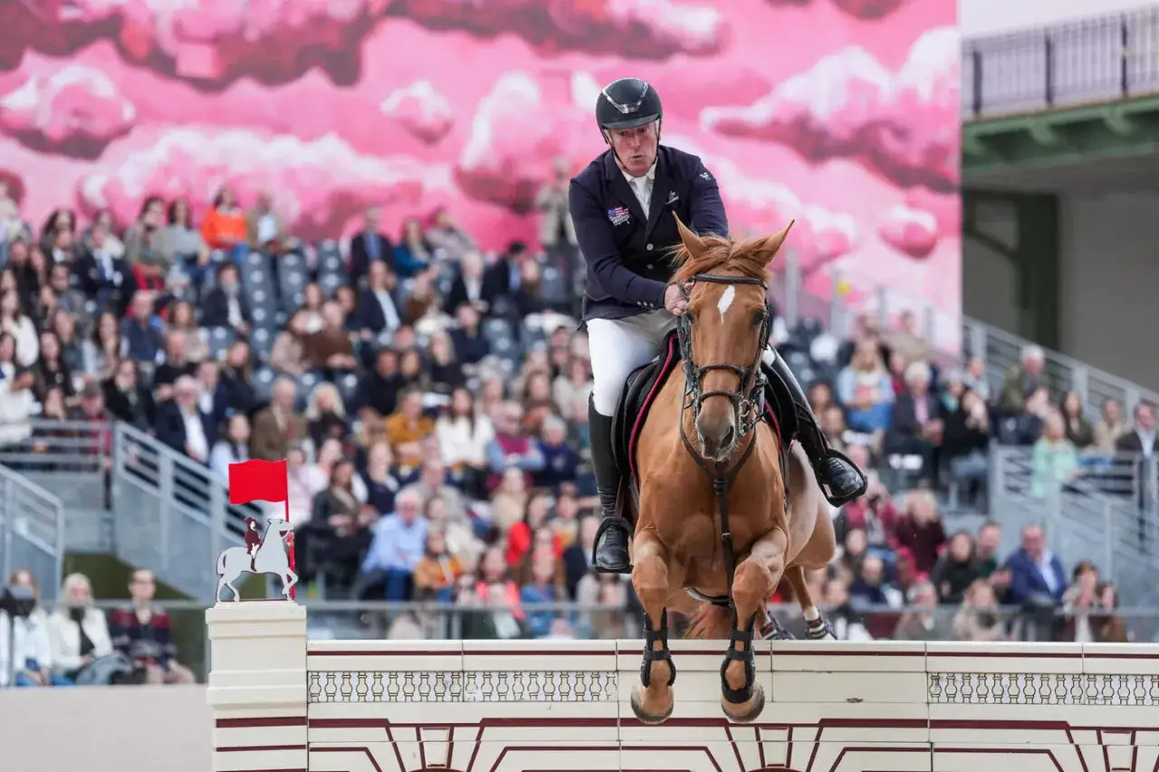 Cavalier et cheval sautent un obstacle, public en arrière-plan. L'idéal de la loge est d'être au plus près de l'action.