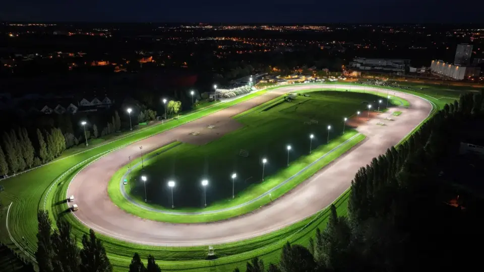 Vue aérienne d'un hippodrome illuminé la nuit, rappelant le nombre d'hippodrome en France.